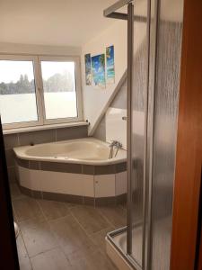 ein Bad mit einer Badewanne und einem Fenster in der Unterkunft Monteur-Pension W8 in Bad Schmiedeberg