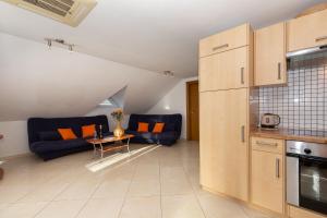 eine Küche und ein Wohnzimmer mit Sofas und einem Tisch in der Unterkunft "Mare et Sol" apartments in Sveti Filip i Jakov