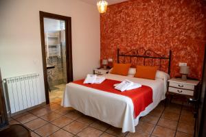 a bedroom with a large bed with orange pillows at La Encomienda de Oreja in Colmenar de Oreja +65 photos