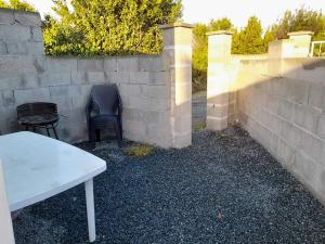 une table et des chaises à côté d'un mur de briques dans l'établissement Maisonnée avec une chambre, à Saint-Michel-en-lʼHerm