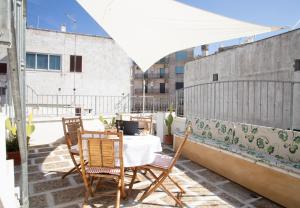 un patio avec une table et des chaises sur un balcon dans l'établissement Casa Zefiro - The Fab Stay, à Ostuni