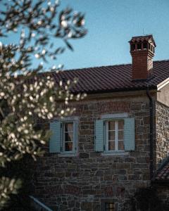 a brick house with a chimney and a window at Villa Majda in Osp