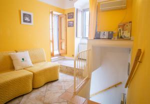 - un salon avec des murs jaunes et un canapé dans l'établissement Casa Zefiro - The Fab Stay, à Ostuni