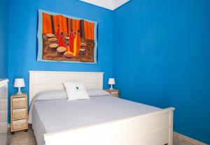 une chambre bleue avec un lit et un tableau mural dans l'établissement Casa Zefiro - The Fab Stay, à Ostuni