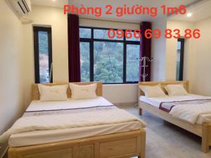 a bedroom with two beds and a window at ĐỨC ANH HOTEL Bảo Lạc in Bảo Lạc