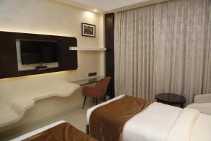 a hotel room with two beds and a flat screen tv at Udman Hotel Chhattarpur in New Delhi