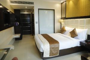 Postel nebo postele na pokoji v ubytování Udman Hotel Chhattarpur