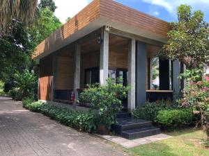 una pequeña casa con plantas delante en Likita Resort, en Ban Phe