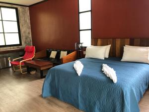 um quarto com uma cama, uma cadeira e uma secretária em Likita Resort em Ban Phe