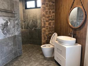 bagno con servizi igienici, lavandino e specchio di Likita Resort a Ban Phe