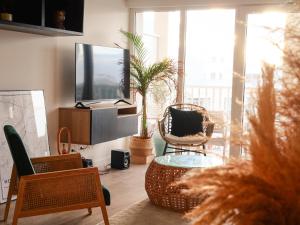 sala de estar con TV, mesa y sillas en B&B : La Loggia Bastide, en Burdeos