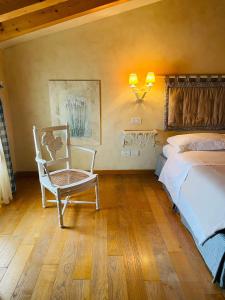 ein Schlafzimmer mit einem Bett und einem Stuhl darin in der Unterkunft Casa Marinelli in Farra di Soligo