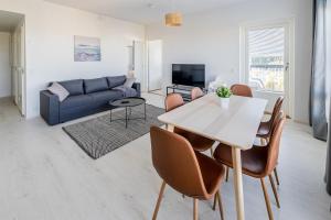 sala de estar con mesa, sillas y sofá en Apartment, SleepWell, Kirstinpuisto en Turku