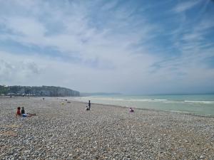 eine Gruppe von Menschen, die an einem felsigen Strand sitzen in der Unterkunft Studio Le Galet idéalement situé en centre ville in Dieppe