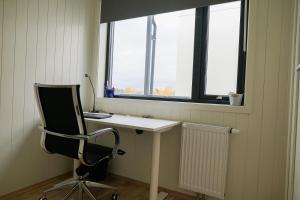 einen Schreibtisch und einen Stuhl in einem Zimmer mit Fenster in der Unterkunft Two bedroom apartment, top floor, stunning views in Eidsvoll