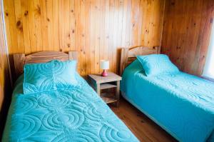 sypialnia z 2 łóżkami i stołem z lampką w obiekcie Casa Pehuen, Cabañas w mieście Villarrica