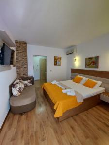a bedroom with a large bed and a chair at VILA MAKA in Budva