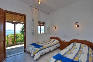 a bedroom with two beds and a balcony at Thea Studios in Kalamakia