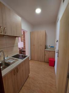 a kitchen with wooden cabinets and a sink at VILA MAKA in Budva