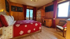 a bedroom with a bed with a red blanket with snowflakes at Casa Margherita Chambres d'Hôtes & SPA in Challand Saint Anselme
