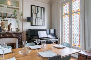 una sala da pranzo con tavolo e pianoforte di Maison d'exception en plein coeur de Nantes a Nantes
