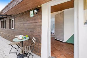 eine Terrasse mit einem Tisch und Stühlen neben einer Wand in der Unterkunft Casa Sanfè in Albenga