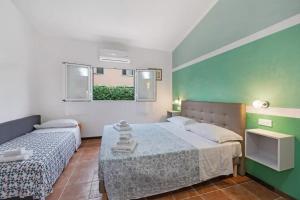 a hotel room with two beds and a window at Casa Sanfè in Albenga