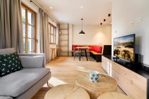 a living room with a couch and a tv at Garten Suite Kirchberg by Alpine Host Helpers in Kirchberg in Tirol