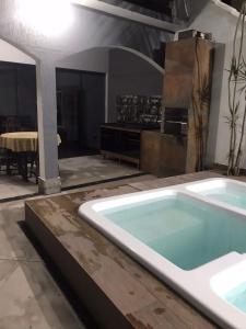 bañera grande en una habitación con mesa en Linda casa com piscina de frente para Praia Grande em Arraial do Cabo-Rj, en Arraial do Cabo