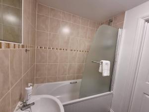 a bathroom with a shower and a sink and a tub at Stockwood Apartment by Cliftonvalley Apartments in Bristol