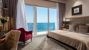 a hotel room with a bed and a large window at Royal Neptun Hotel in Dubrovnik