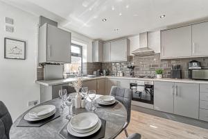 a kitchen with a table and chairs and a dining room at Guest Homes - Rose Cottage in Worcester