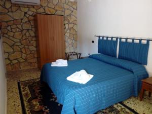 a bedroom with a blue bed with towels on it at U Puzzu Ranne in Buseto Palizzolo