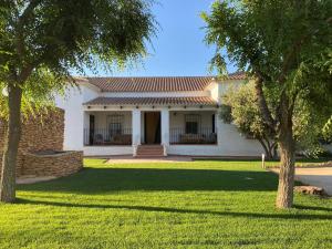 a white house with a yard with two trees at Casa La Regidora in Cinco Casas