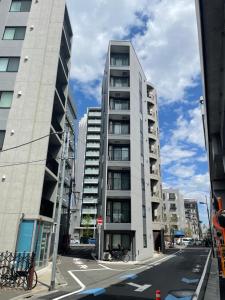 um edifício alto numa rua da cidade com edifícios em Kamatas STAY 京急蒲田駅 徒歩5分 em Tóquio