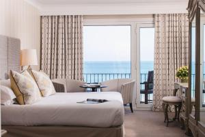 a bedroom with a bed and a view of the ocean at St Brelade's Bay Hotel in St. Brelade