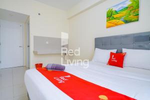茂物的住宿－RedLiving Apartemen Bogorienze Resort - Skyland Tower A，一间卧室配有一张床铺,床上铺有红色毯子