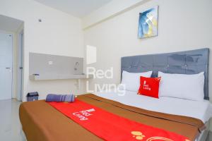 茂物的住宿－RedLiving Apartemen Bogorienze Resort - Skyland Tower A，一间卧室配有红色和白色枕头的床
