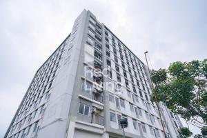 ein weißes Gebäude mit einem Schild an der Seite in der Unterkunft RedLiving Apartemen Bogorienze Resort - Skyland Tower A in Bogor