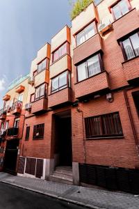 un edificio de ladrillo rojo con una puerta y escaleras. en Homenfun Madrid Tetuán, en Madrid