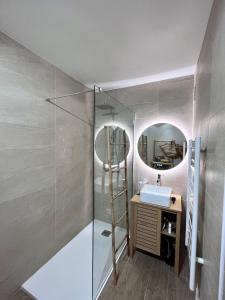 W łazience znajduje się prysznic, umywalka i lustro. w obiekcie CAP6 Bel appartement vue magnifique mer, Piscine Tennis T3 refait à neuf w Cassis