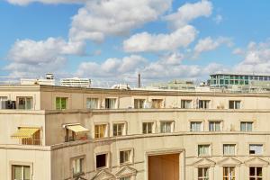 un gran edificio blanco con cielo en Hôtel Orchidée, en París