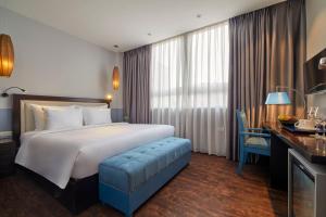 Pokój hotelowy z dużym łóżkiem i biurkiem w obiekcie HANOI FLORA HOTEL w mieście Hanoi