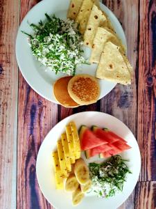 dos platos de comida en una mesa de madera en Isla Dhiffushi en Dhiffushi