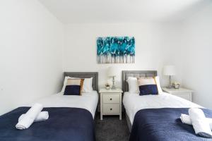 two beds sitting next to each other in a bedroom at Dressed To Impress 2 bed house in Heart of Croydon Photo ID Required in Croydon