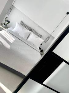 a bed with white sheets and pillows in a room at Noi leisure stay 3 in Neoi Epivates