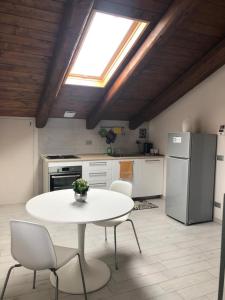 - une table et des chaises blanches dans une cuisine avec une fenêtre dans l'établissement La Cinciallegra, à Govone