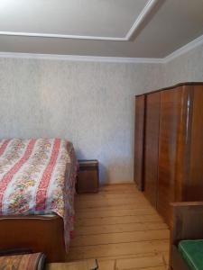 a bedroom with a bed and a wooden cabinet at Dusheti Baga in Dushetʼi