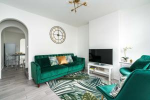 a living room with a green couch and a tv at Dressed to impress 2 bed house in Heart of Croydon ID Required in Croydon