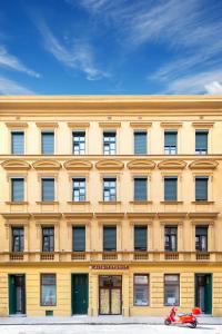 a yellow building with a scooter parked in front of it at Altwienerhof Aparthotel in Vienna